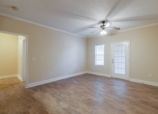 A room with a ceiling fan and two doors.