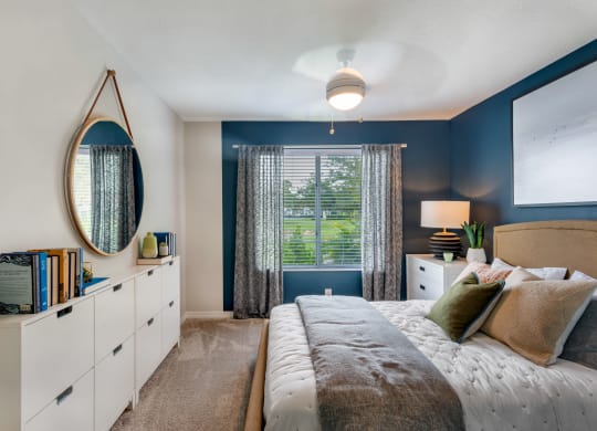 a bedroom with blue walls and a large bed and a window at The Villas at Ibis Landing, Florida, 33067