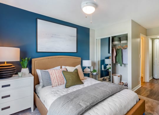 a bedroom with a bed and a blue wall and a closet at The Villas at Ibis Landing, Parkland, Florida