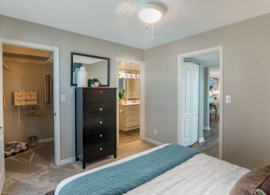a bedroom with a bed and a dresser and a bathroom at The Villas at Ibis Landing, Parkland