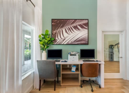 a home office with two computer monitors and a desk with two chairs at The Villas at Ibis Landing, Parkland, Florida