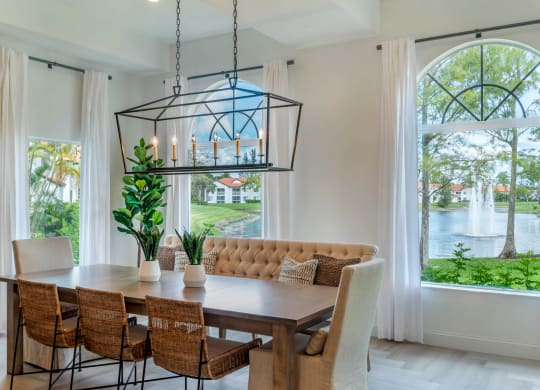 a dining room with a table and chairs and a large window at The Villas at Ibis Landing, Parkland, 33067