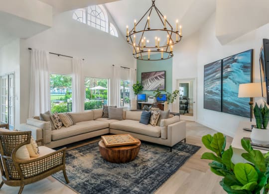 a living room with a large couch and a chandelier at The Villas at Ibis Landing, Parkland, Florida