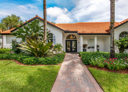 a house with a walkway and palm trees at The Villas at Ibis Landing, Florida, 33067