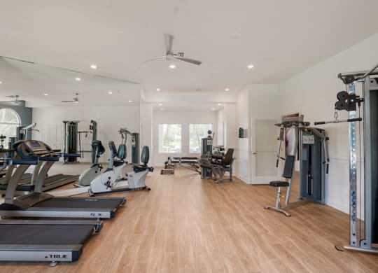 the gym with treadmills and other exercise equipment at the flats at west end at The Villas at Ibis Landing, Parkland