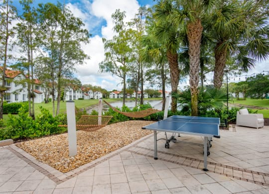 the patio has a ping pong table and a hammock at The Villas at Ibis Landing, Parkland, Florida