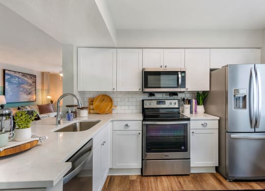 a kitchen with stainless steel appliances and white cabinets at The Villas at Ibis Landing, Florida
