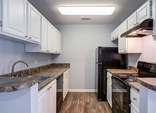 A kitchen with black appliances and white cabinets.