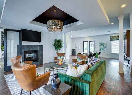 A living room with a green couch and a fireplace.