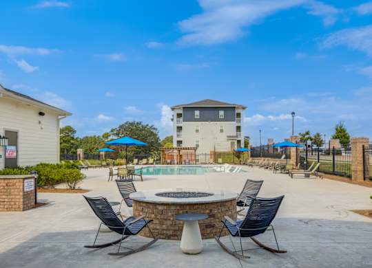 A poolside area with chairs and a fountain.