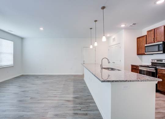 A kitchen with a white countertop and wooden cabinets.