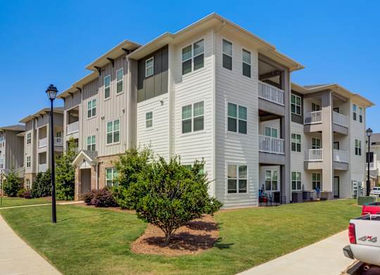 A large apartment complex with a red truck parked in front.