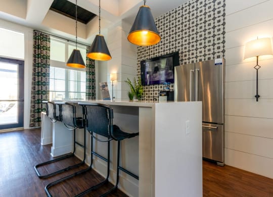 a kitchen with a bar and a stainless steel refrigerator