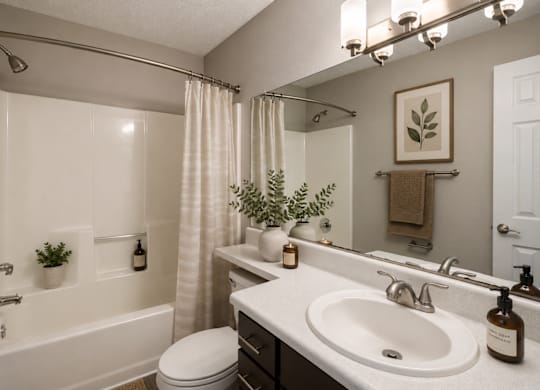 A bathroom with a white sink and a white toilet at Southland Station Apartments in Warner Robins, 31088