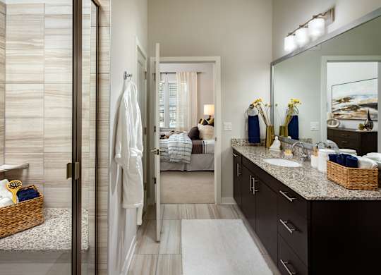 A bathroom with a walk-in shower and a large mirror.