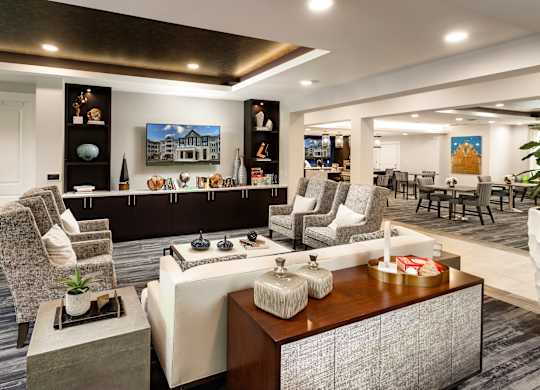 A modern living room with a large sofa set, a coffee table, and a painting on the wall.