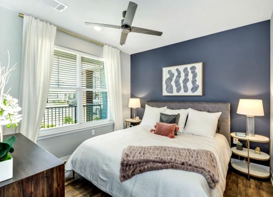 a bedroom with a large bed and a ceiling fan at Farmhaus Apartments, Madison, AL, 35757