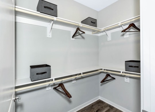 a closet with white walls and shelves and hangers with shoes at Farmhaus Apartments, Madison, Alabama