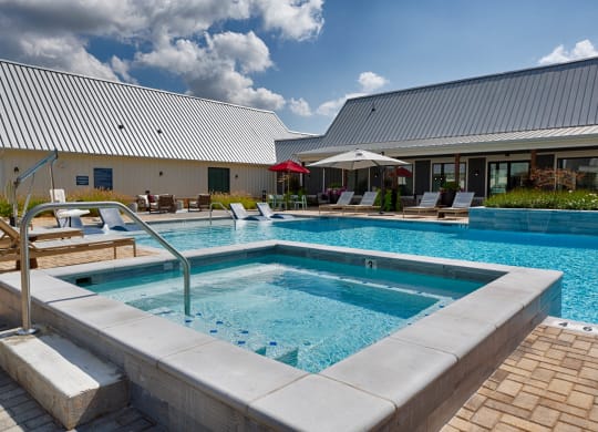 people are standing around a swimming pool at Farmhaus Apartments, Madison, 35757