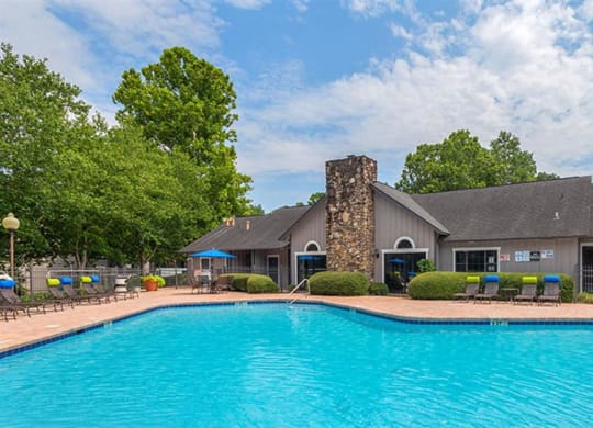 a large swimming pool in front of a house at High Ridge Apartments, Athens Georgia