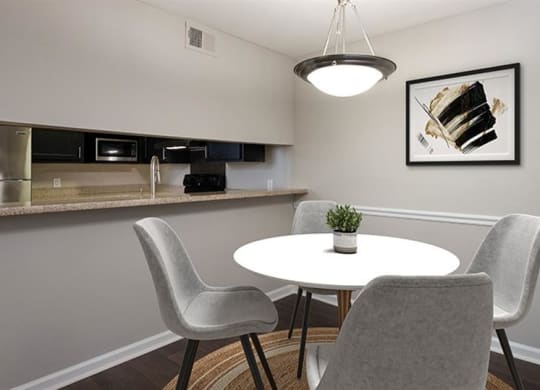 a small dining room with a white table and chairs at High Ridge Apartments, Athens Georgia