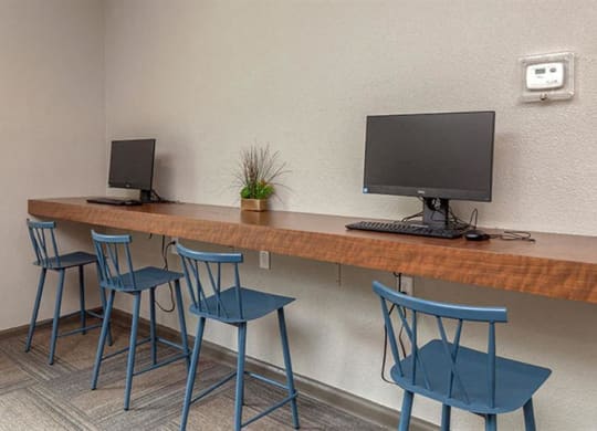 a desk with three chairs and a computer on it at High Ridge Apartments, Athens