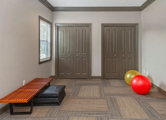 a room with two doors and a red ball and a bench  at High Ridge Apartments, Athens, GA 30606