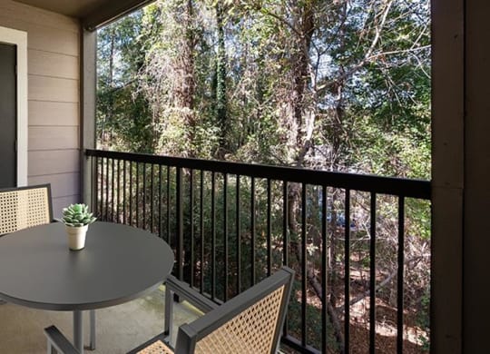 a patio with a table and chairs on a balcony at High Ridge Apartments, Georgia