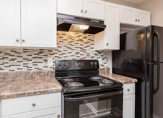 A kitchen with a black stove and refrigerator. at Bradford Pointe, Augusta, GA