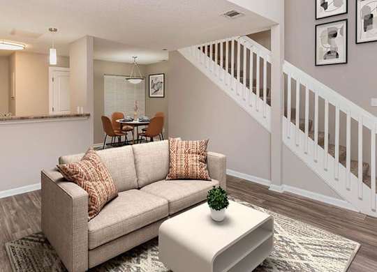 A living room with a couch, a coffee table, and a staircase. at Bradford Pointe, Augusta, 30909