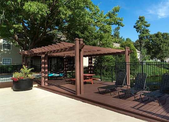 A wooden deck with a pergola and chairs. at Bradford Pointe, Augusta, Georgia