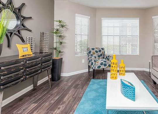 A living room with a couch, a coffee table, and a window with blinds. at Bradford Pointe, Augusta, 30909