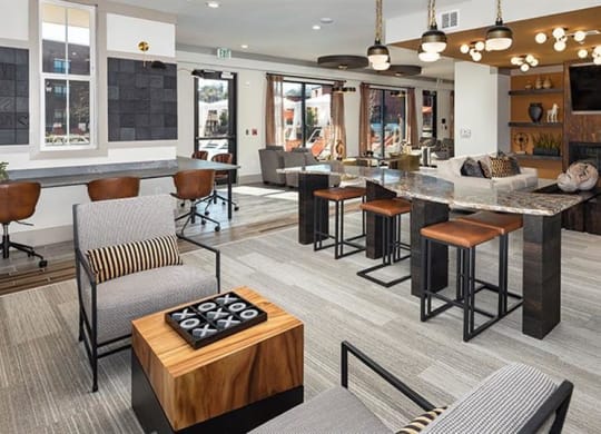 a clubhouse with a bar and a living room with furniture at The Flats at Southlawn Apartments, Lawrenceville, GA
