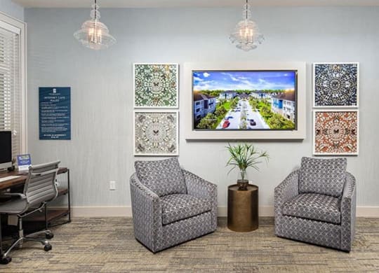 a lobby with two chairs and a tv on the wall at Promenade at Newnan Crossing, Georgia