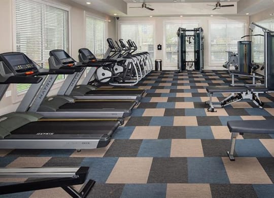 a gym with cardio machines and weights on a checkered floor at Promenade at Newnan Crossing, Newnan, 30265