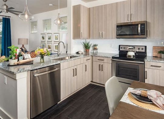 a kitchen with stainless steel appliances and a table at Promenade at Newnan Crossing, Newnan, GA