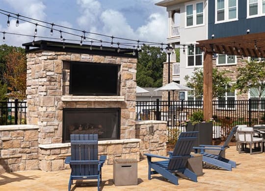 a patio with a fireplace and tables and chairs at Promenade at Newnan Crossing, Georgia, 30265