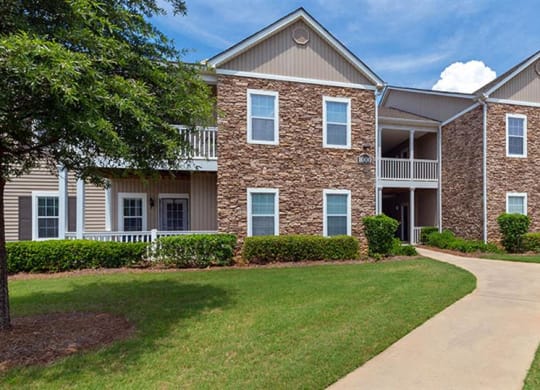 an apartment building with a sidewalk in front of it at Bedford Parke Apartments, Warner Robins Georgia
