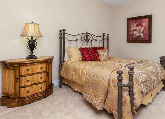 a bedroom with a bed and a dresser at Bedford Parke Apartments, Warner Robins Georgia