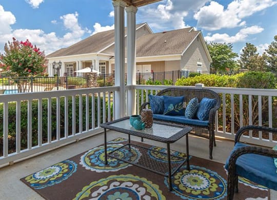 a patio with two chairs and a table on a balcony at Bedford Parke Apartments, Georgia