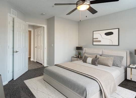A bedroom with a large bed and a ceiling fan.