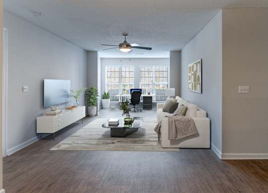 A living room with a white couch, a coffee table, and a television.