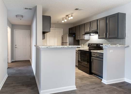 A kitchen with black cabinets and a white countertop.