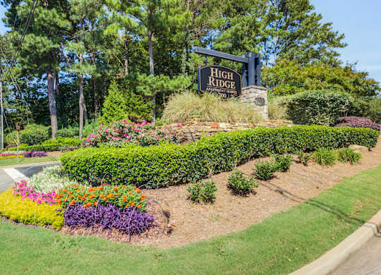 A sign that says High Ridge stands in front of a landscaped area.