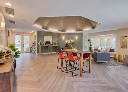 a resident clubhouse with a table with four chairs and a couch in the background at Hunters Chase Apartments, Midlothian
