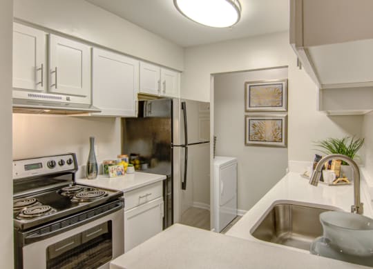 a kitchen with white cabinetry and stainless steel appliances at Hunters Chase Apartments, Virginia