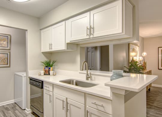 a kitchen with white cabinets and a sink at Hunters Chase Apartments, Midlothian, Virginia