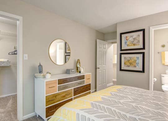 a bedroom with a bed and a dresser with a mirror on top of it at Hunters Chase Apartments, Midlothian