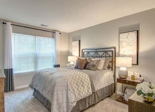 a bedroom with a bed and two night stands with lamps at Hunters Chase Apartments, Virginia,23112