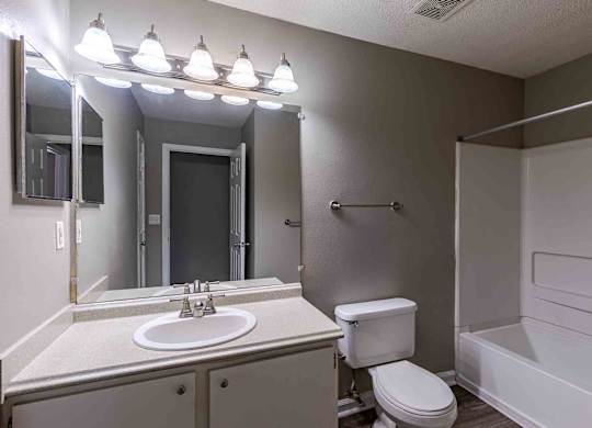 A bathroom with a white sink, toilet, and bathtub.